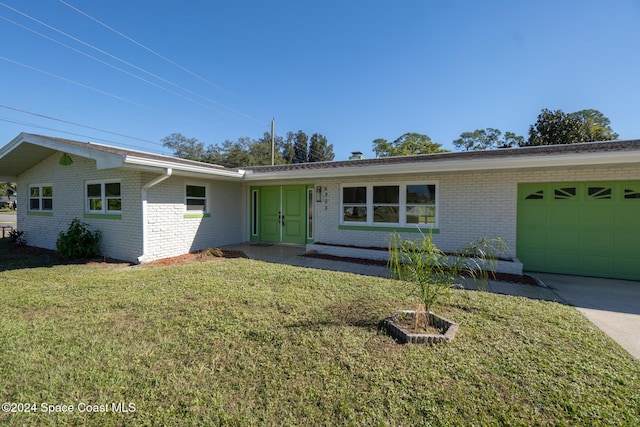 8303 Sylvan Dr, Melbourne, FL 32904 - ranch-style home with a garage, brick siding, a front lawn, and concrete driveway