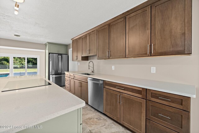 8303 Sylvan Dr, Melbourne, FL 32904 - kitchen with appliances with stainless steel finishes, a sink, light countertops, and a textured ceiling