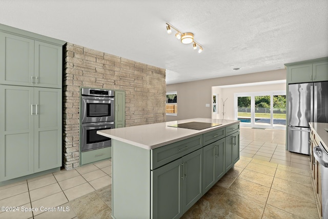 8303 Sylvan Dr, Melbourne, FL 32904 - kitchen with green cabinetry, stainless steel appliances, light countertops, plenty of natural light, and a textured ceiling