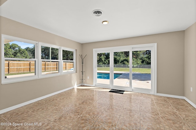 tiled empty room featuring a healthy amount of sunlight