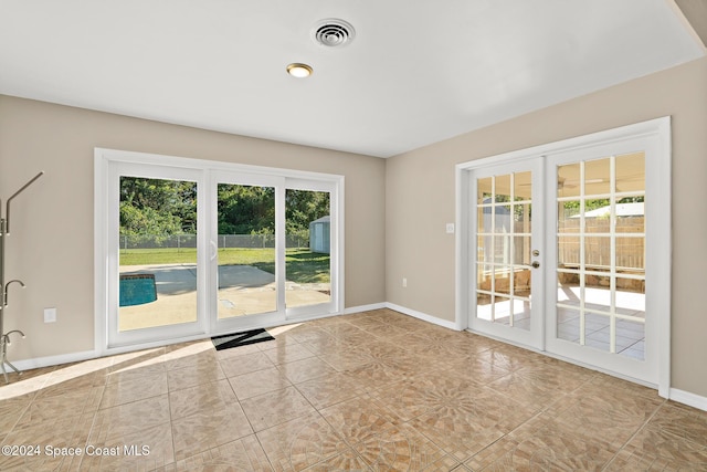 unfurnished room featuring light tile patterned floors and french doors