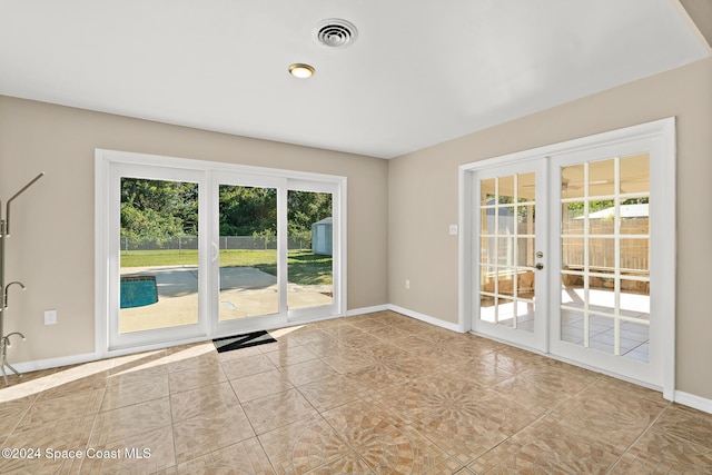 8303 Sylvan Dr, Melbourne, FL 32904 - tiled empty room featuring french doors and baseboards