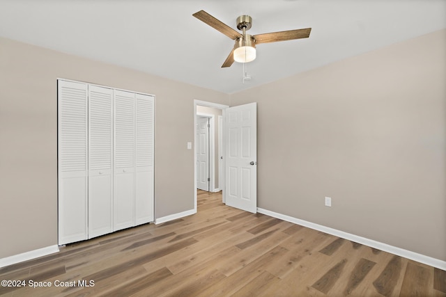 unfurnished bedroom featuring ceiling fan, a closet, and light hardwood / wood-style flooring