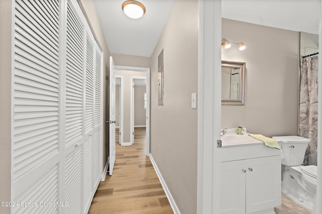 8303 Sylvan Dr, Melbourne, FL 32904 - corridor featuring a sink, light wood-style flooring, and baseboards