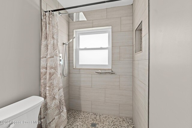 8303 Sylvan Dr, Melbourne, FL 32904 - bathroom with a tile shower and toilet