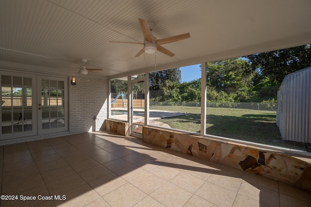 unfurnished sunroom with ceiling fan