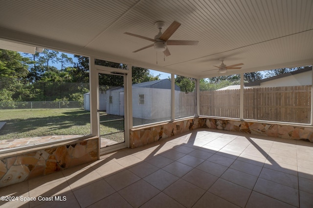 unfurnished sunroom with ceiling fan