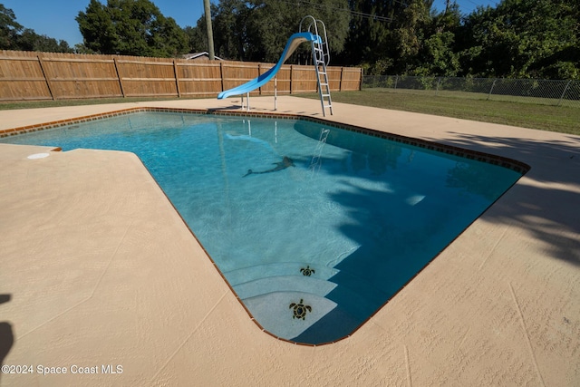 8303 Sylvan Dr, Melbourne, FL 32904 - view of swimming pool with a water slide, a fenced backyard, and a patio