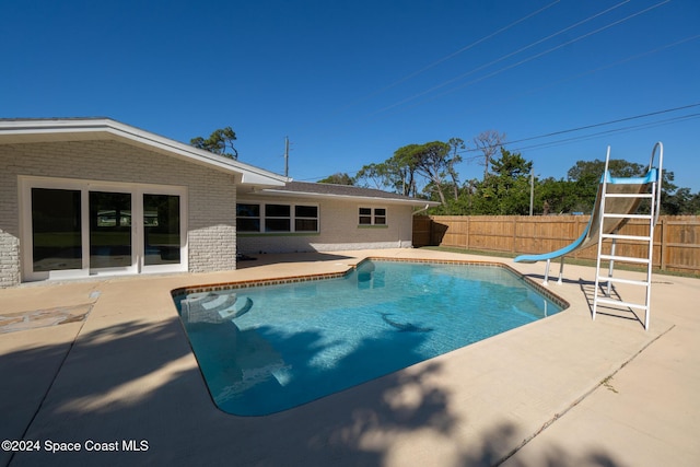 8303 Sylvan Dr, Melbourne, FL 32904 - view of swimming pool featuring a water slide, a patio area, and a fenced backyard