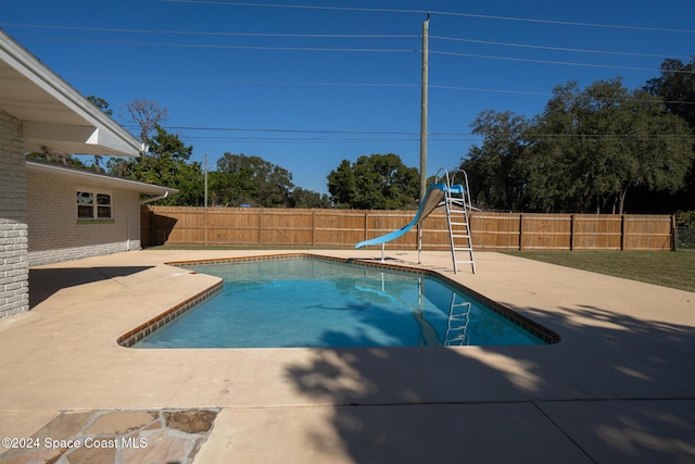 8303 Sylvan Dr, Melbourne, FL 32904 - view of swimming pool featuring a water slide, a patio area, and a fenced backyard