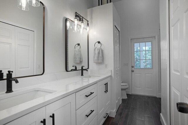 bathroom with hardwood / wood-style floors, vanity, and toilet