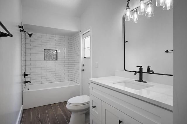 full bathroom featuring vanity, wood-type flooring, tiled shower / bath combo, and toilet