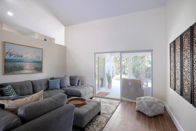 living room with high vaulted ceiling and wood-type flooring