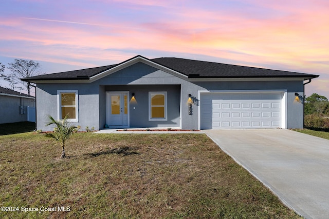 ranch-style house with a yard and a garage