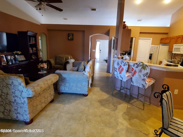 living room featuring ceiling fan and vaulted ceiling