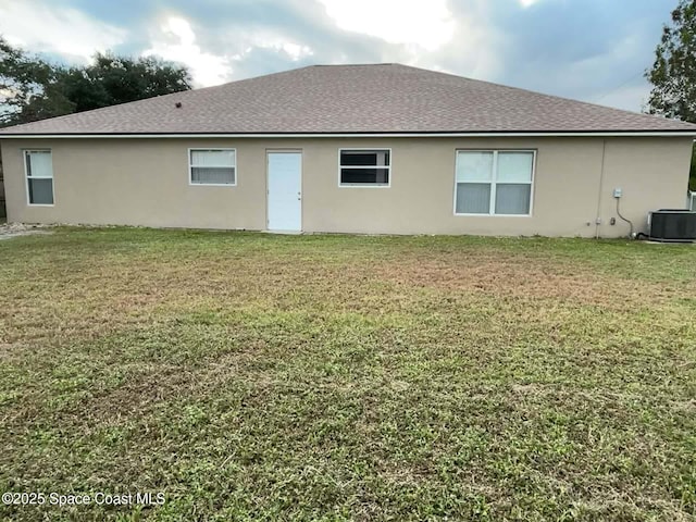 rear view of property with a lawn and central AC unit