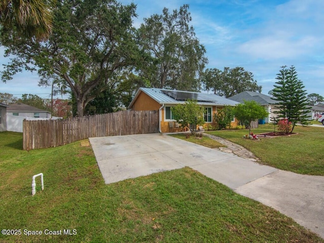 ranch-style home with a front lawn and solar panels