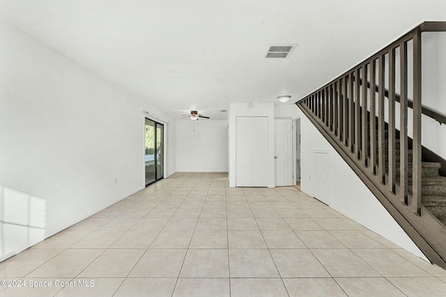 unfurnished living room featuring ceiling fan and light tile patterned floors