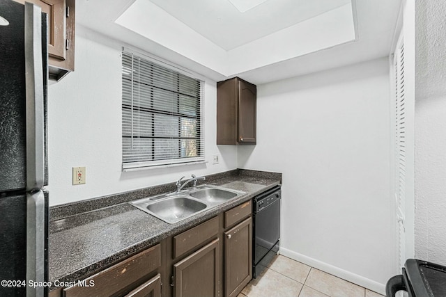 kitchen featuring light tile patterned floors, sink, dark brown cabinetry, and black appliances