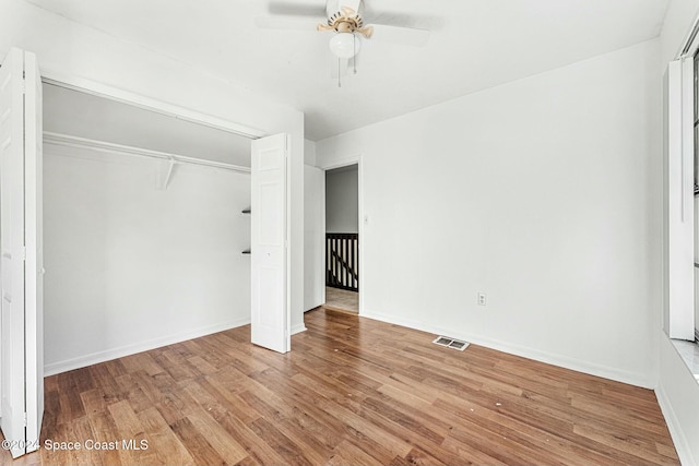 unfurnished bedroom with wood-type flooring, a closet, and ceiling fan