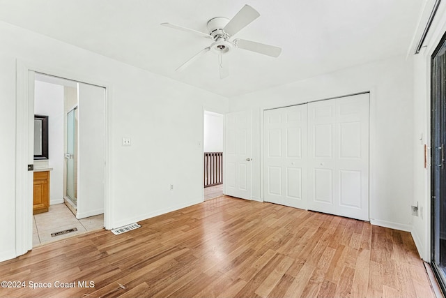 unfurnished bedroom featuring ceiling fan, a closet, connected bathroom, and light hardwood / wood-style flooring