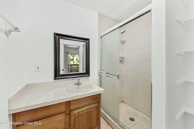 bathroom with a shower with door and vanity