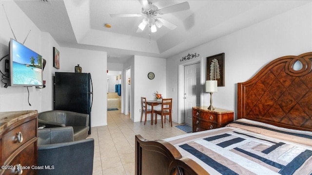 tiled bedroom featuring ensuite bathroom, ceiling fan, and a tray ceiling