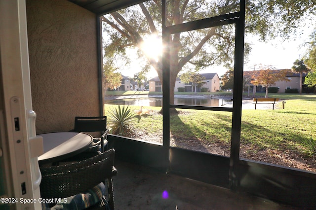 sunroom / solarium featuring plenty of natural light and a water view