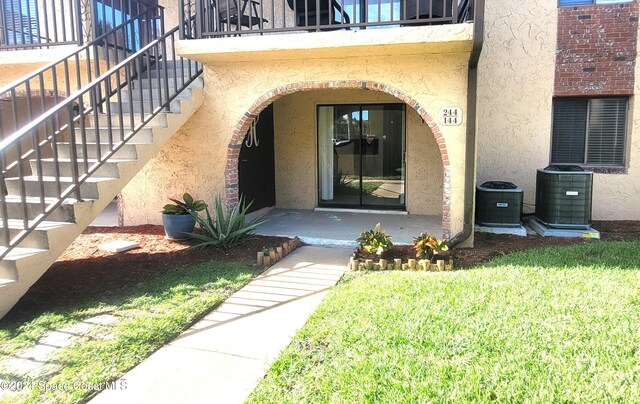 144 San Paulo Cir Unit 10-144, West Melbourne, FL 32904 - doorway to property with stucco siding, a lawn, and a balcony