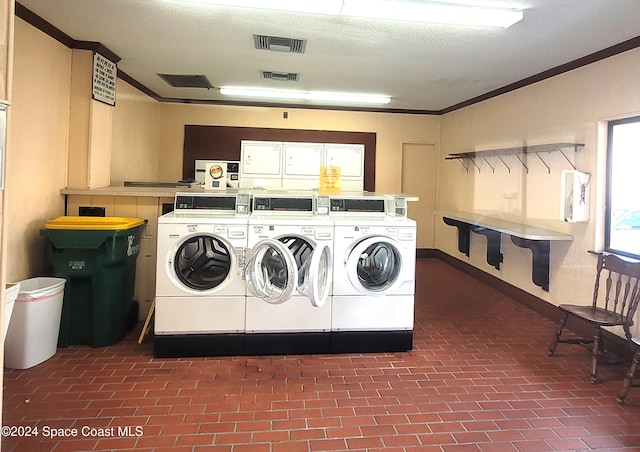 clothes washing area with ornamental molding and a textured ceiling