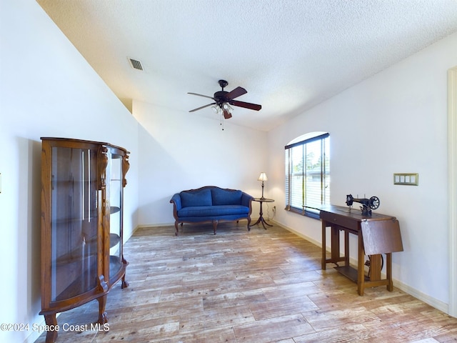 sitting room featuring ceiling fan, a textured ceiling, and light wood-type flooring