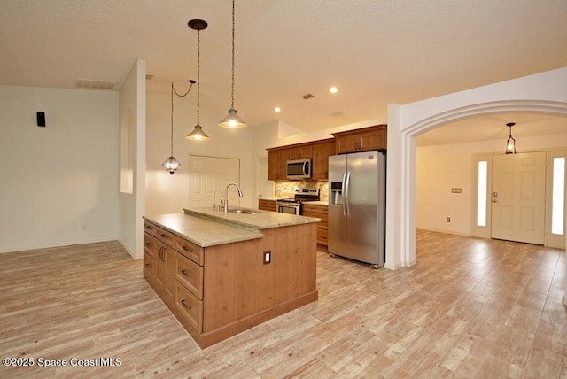 kitchen with light hardwood / wood-style floors, hanging light fixtures, and appliances with stainless steel finishes