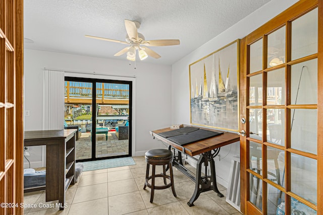 dining room with ceiling fan, french doors, light tile patterned flooring, and a textured ceiling