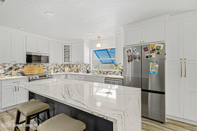 kitchen with a center island, white cabinetry, and appliances with stainless steel finishes