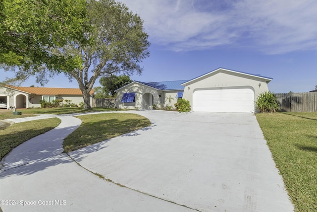 ranch-style home featuring a front lawn and a garage