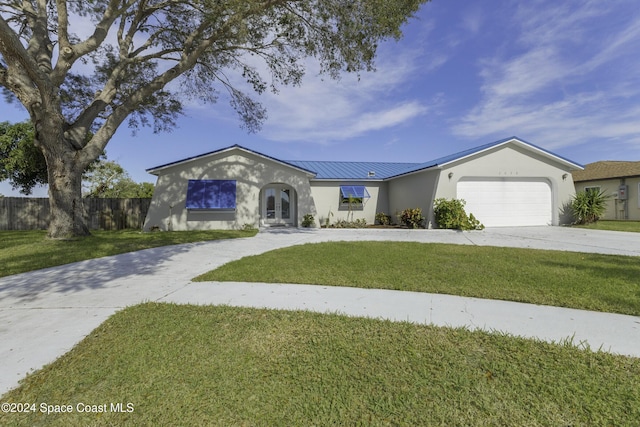 view of front of property featuring a garage, a front yard, and french doors