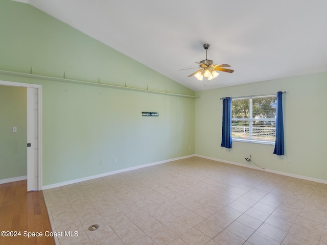 tiled empty room with ceiling fan and lofted ceiling