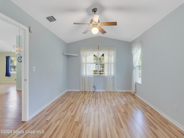 empty room featuring light hardwood / wood-style floors, a wealth of natural light, and vaulted ceiling