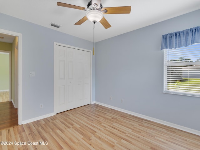 unfurnished bedroom with light wood-type flooring, a closet, and ceiling fan