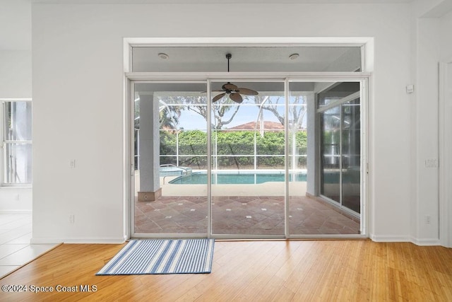 doorway with hardwood / wood-style flooring and ceiling fan