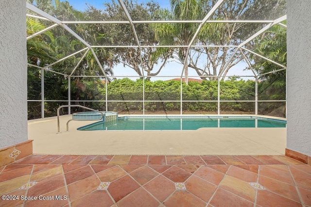 view of pool featuring a lanai, a patio area, and an in ground hot tub