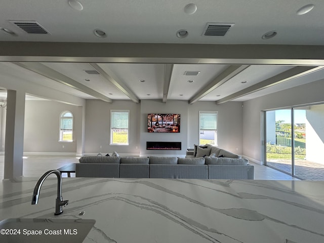 living room with beam ceiling and a wealth of natural light