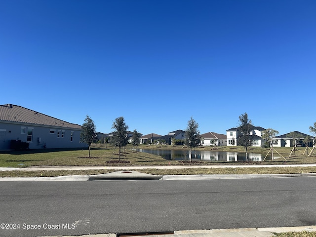 view of front facade featuring a water view and a front lawn