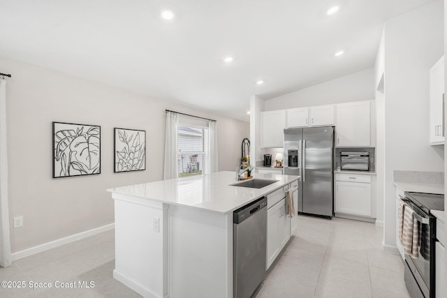 kitchen with stainless steel appliances, sink, white cabinetry, lofted ceiling, and an island with sink