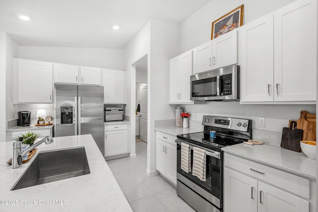 kitchen with light stone countertops, sink, and stainless steel appliances