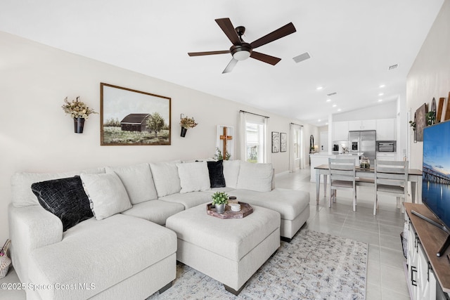 tiled living room featuring ceiling fan and vaulted ceiling