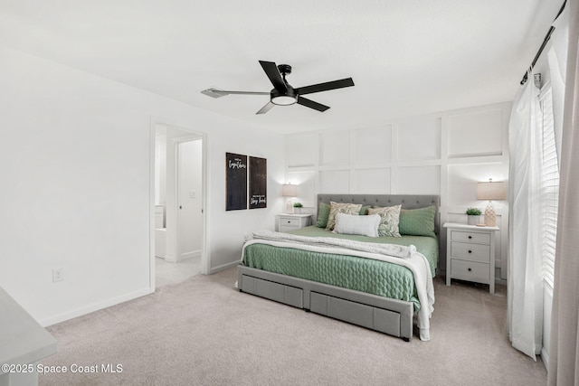 carpeted bedroom with ensuite bathroom and ceiling fan