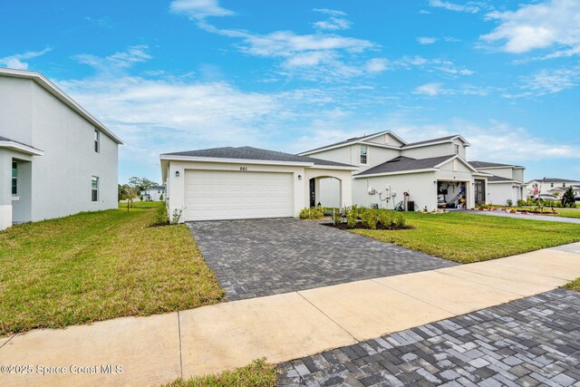 view of front of home with a front yard and a garage