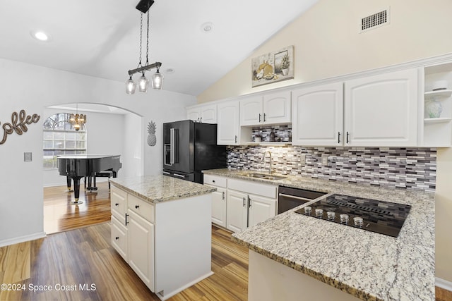 kitchen featuring sink, black appliances, white cabinets, a kitchen island, and hanging light fixtures