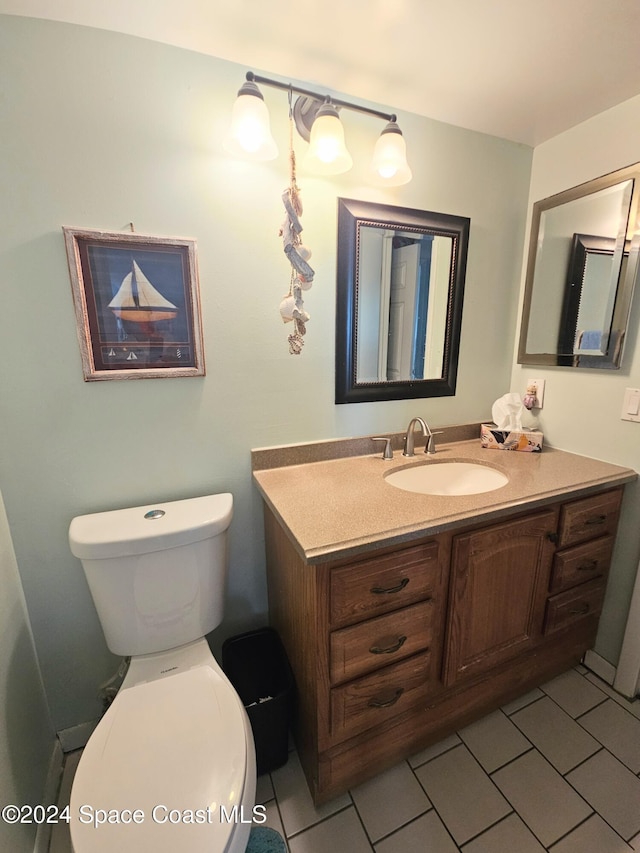 bathroom with tile patterned flooring, vanity, and toilet